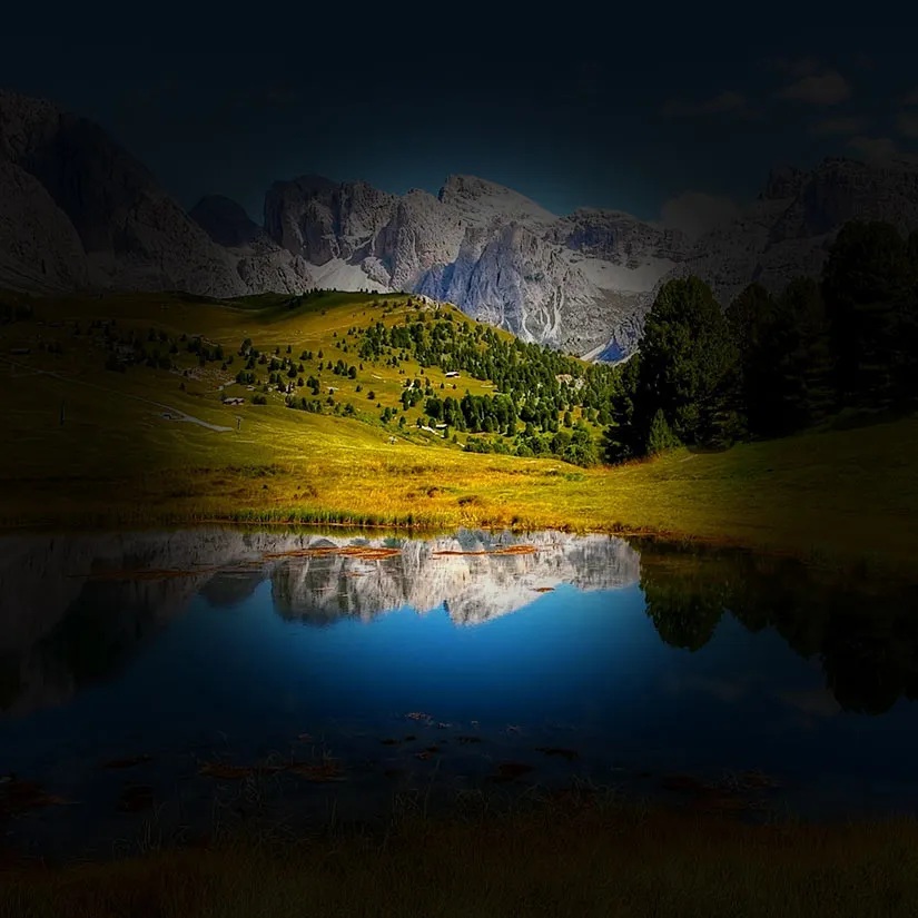 Retinitis-Pigmentosa-Lanscape Simulation of retinitis pigmentosa showing a mountain landscape and reflective lake where the peripheral visual field is blacked out and the central portion provides a shadowy frame of scenery that is visible and clear.